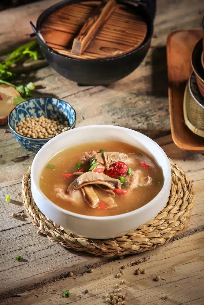 Bowl of soup with ingredients on a wooden table