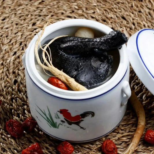 Traditional Chinese herbal soup for confinement in a ceramic jar on a woven mat