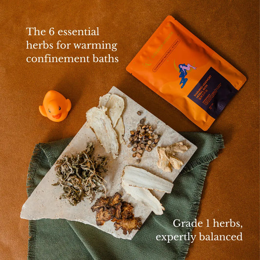 Herbs for warming confinement baths on a stone slab with packaging on a brown background