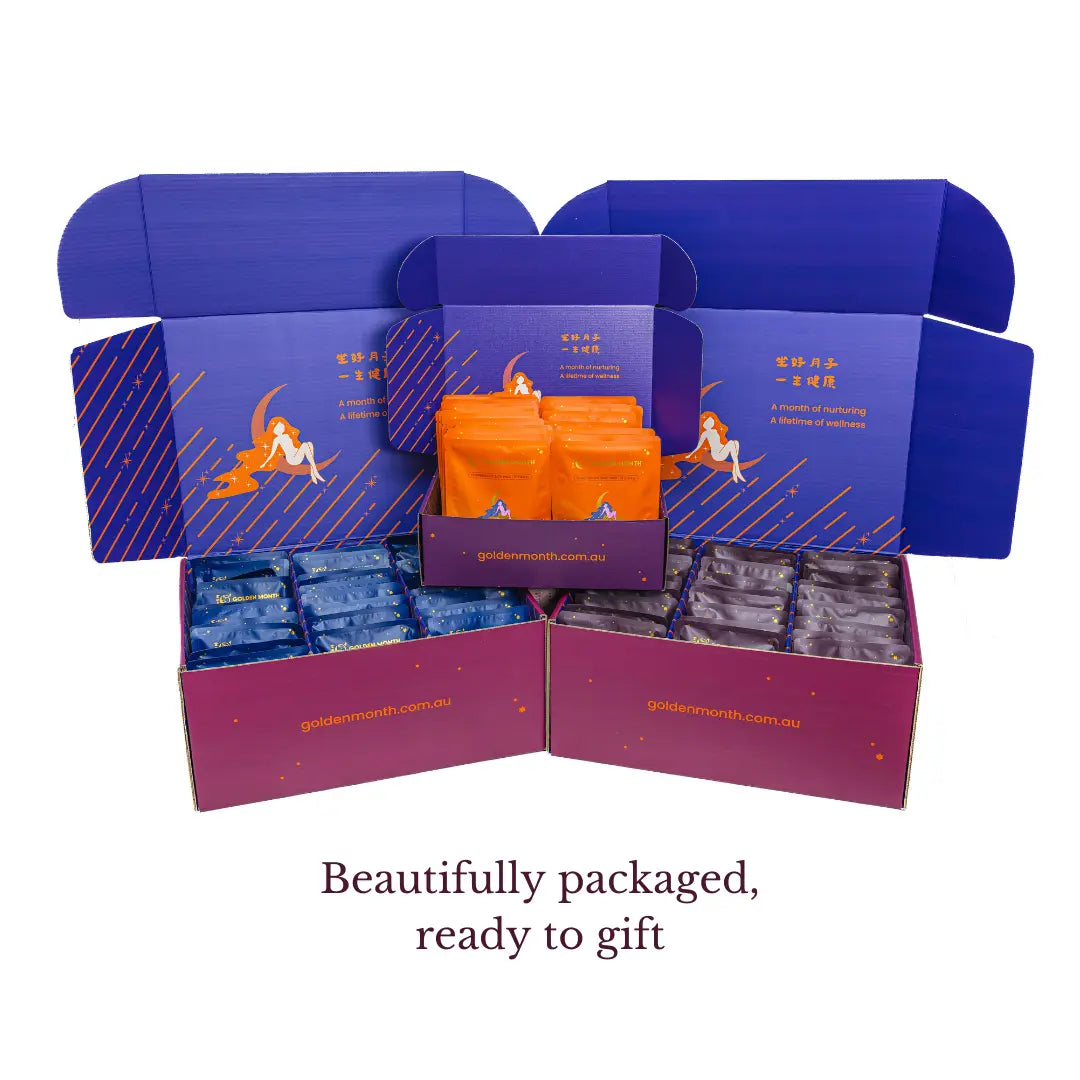 Open gift box with blue and purple packaging containing soup, tea and bath pacls for postpartum.