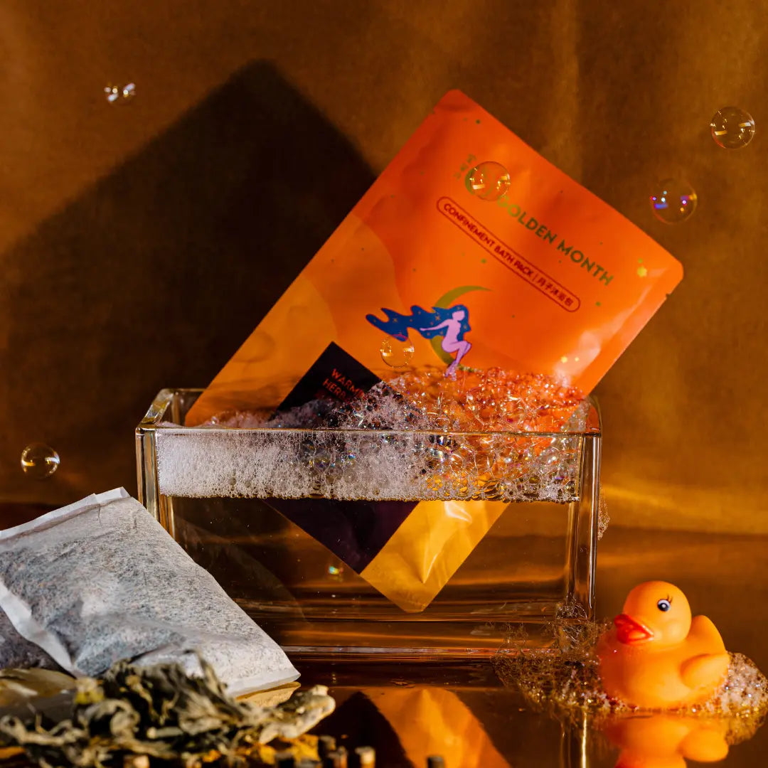 Orange tea bag packaging with a rubber duck and tea leaves on a reflective surface