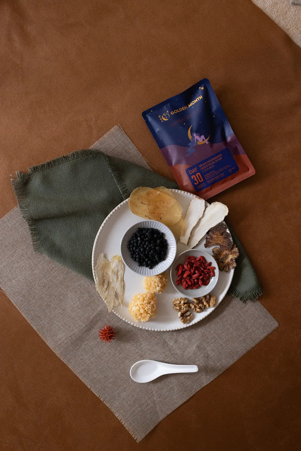 Assorted food items on a plate with a package of tea on a brown surface