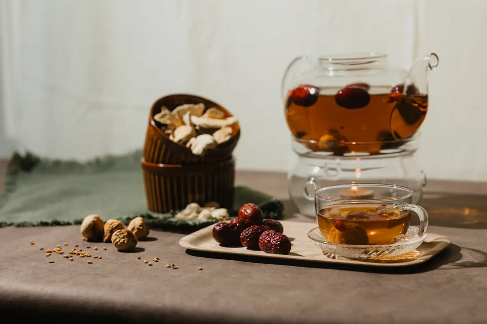 Tea set with a teapot, cup, and snacks on a table.