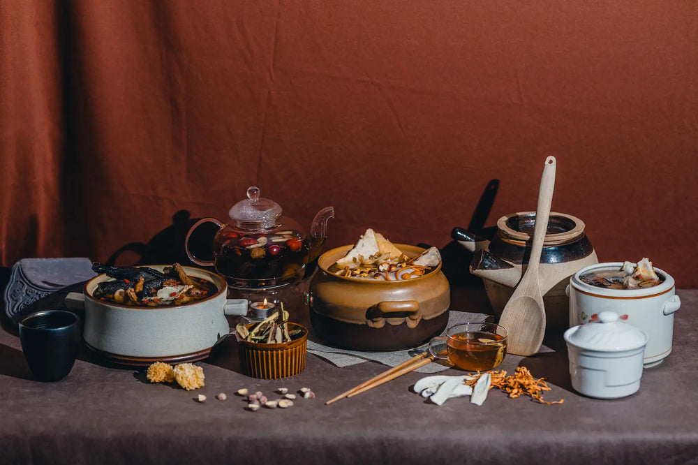 Table setup with various ceramic dishes, utensils, and food items against a brown background