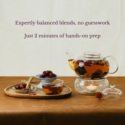Tea-making setup with a teapot, cups, and ingredients on a wooden surface.